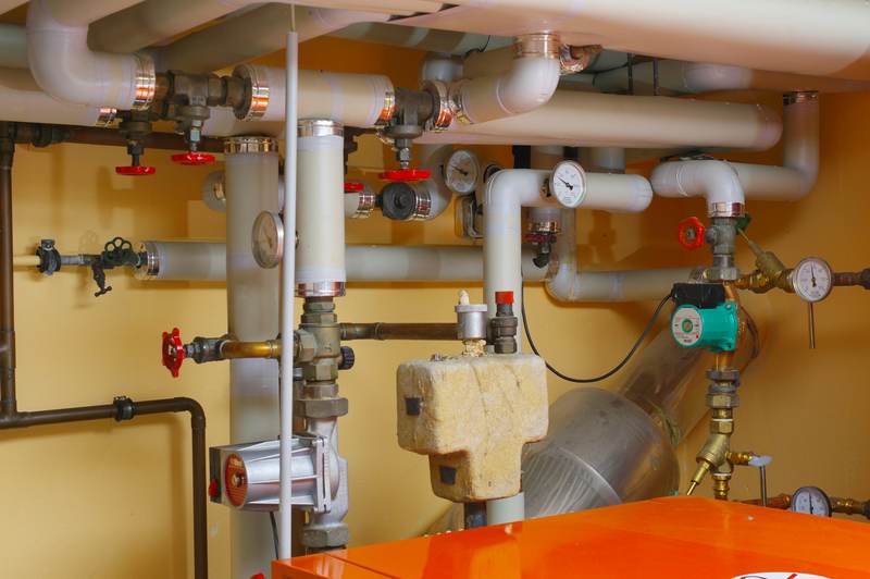 Boiler room with insulated supply pipes, valves, and a circulator pump