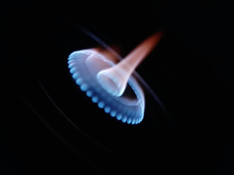 Blue gas burner flame against a dark background